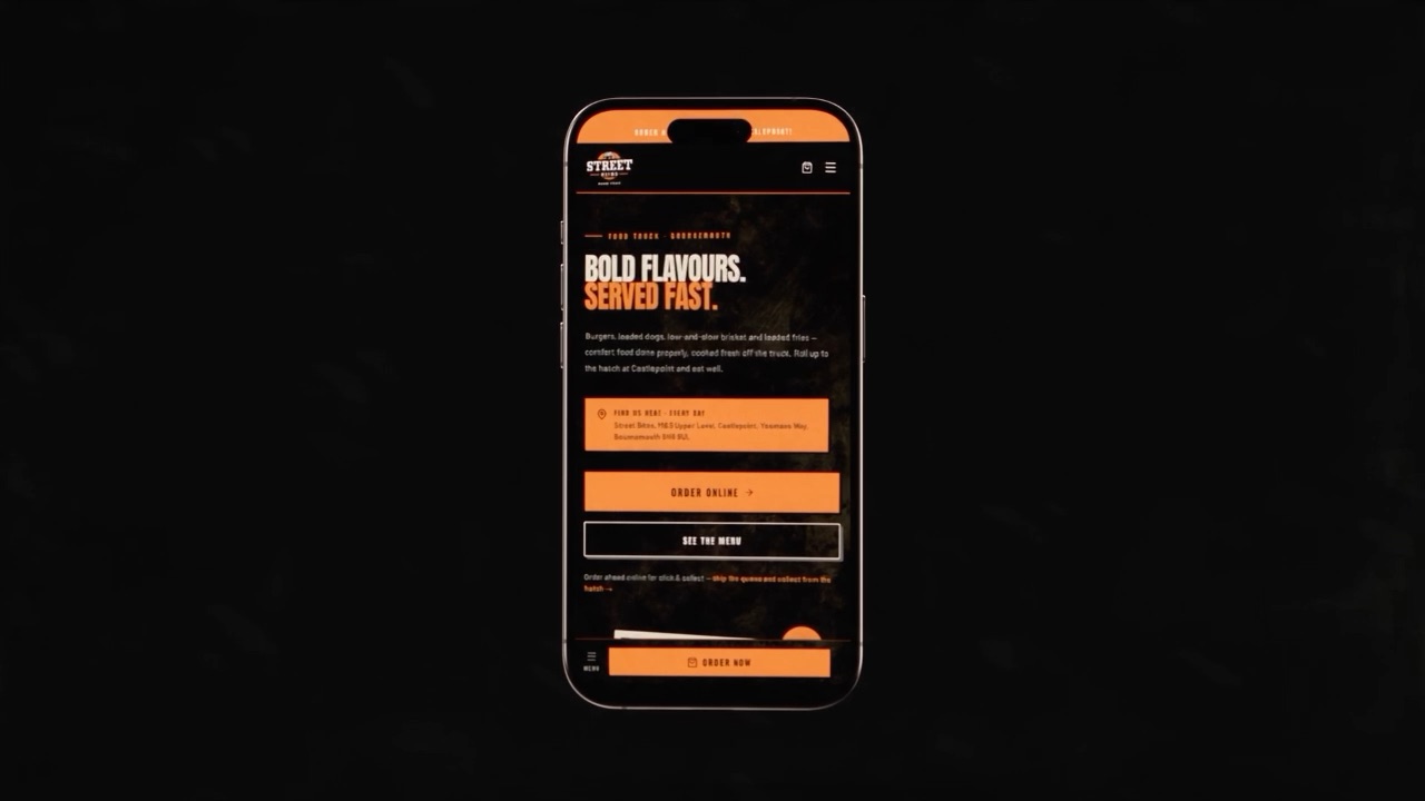 The Street Bites site on a phone held square to camera, showing the stacked mobile homepage with full-width Order Online and See The Menu buttons.